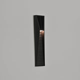 The step light lit at an angle on a facade with the louvers picked out