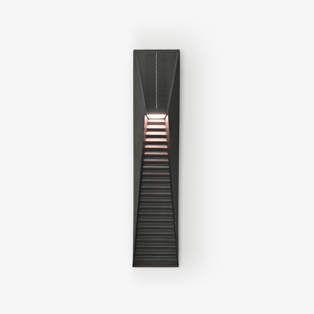 Slim black wedge step light with a louvered lower face on a pale wall
