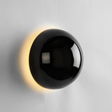 The black sphere lit, warm light around its edge