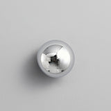 The chrome sphere on a pale wall, reflecting the room