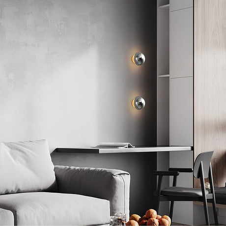 Two chrome spheres lit beside a sofa and a desk with a chair