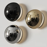 The three finishes, black, gold and chrome, side by side on a wall
