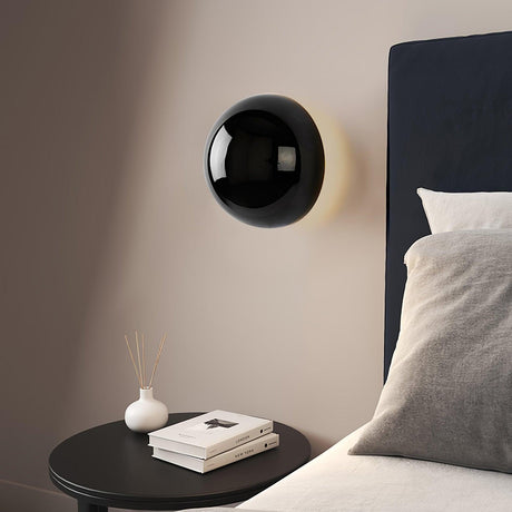 The black sphere beside a dark headboard above a round side table
