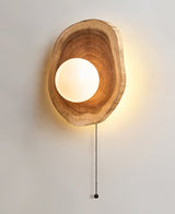 The wood slab unlit, the white sphere sitting in its hollowed opening