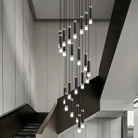 Spiral cluster of slim lit cylinders dropping beside a pale concrete staircase