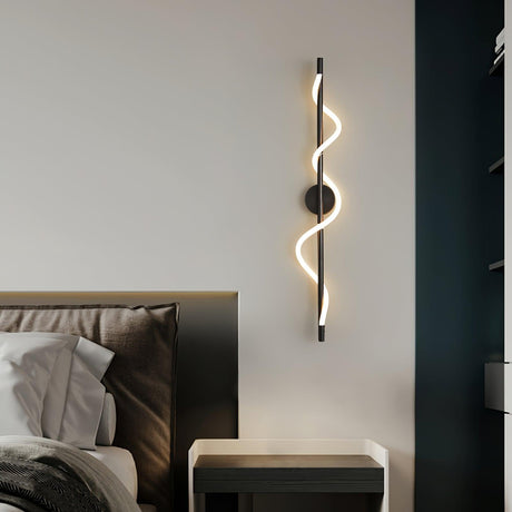 The lit spiral on a dark wall beside a bed and a low nightstand