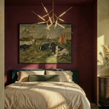 The gold version lit above a bed with pillows below a framed painting on a burgundy wall