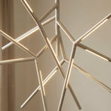 The chrome arms lit against a pale wall, showing how the rods meet at the hub
