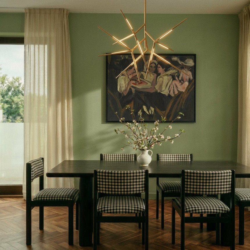 The gold version over a dining table with checked chairs, a vase and framed art