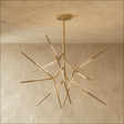 A gold sputnik chandelier whose lit arms radiate in every direction from one hub