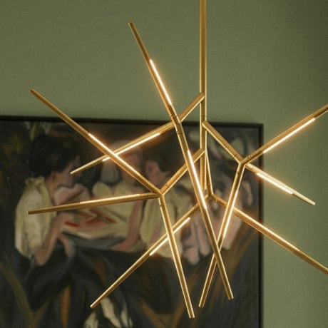 The lit gold arms in front of a green wall and a framed painting