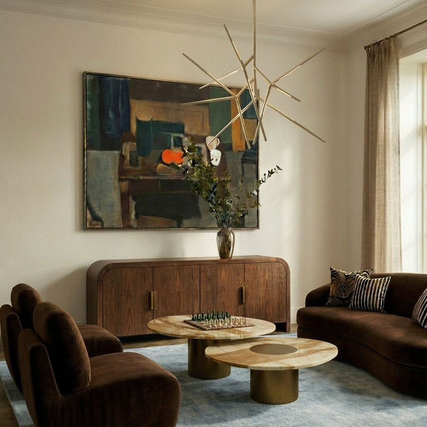 The gold version in a living room above a sideboard, sofa and two round coffee tables