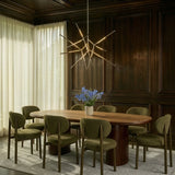 The gold version above a dining table and chairs in a dark wood paneled room with curtains