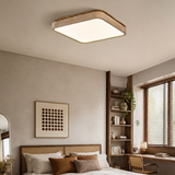 Square travertine ceiling light lit above a bed beside a tall shelving unit