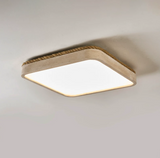 Square travertine ceiling light lit and seen from below at an angle