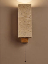 The block lit on a dark wall with the pull chain hanging below the bracket