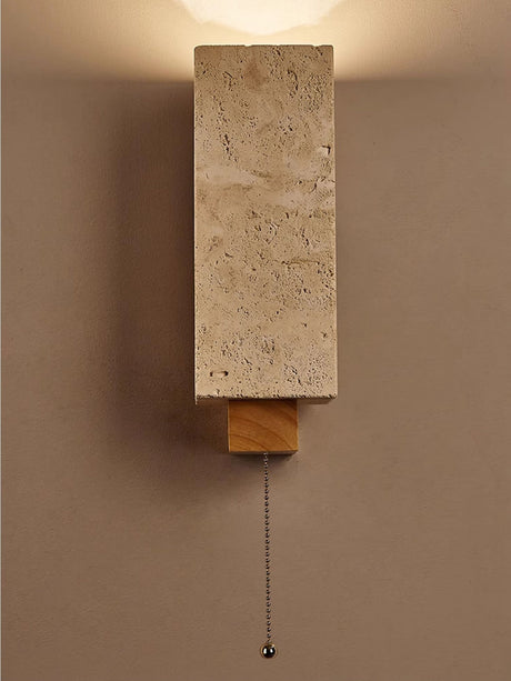 The block lit on a dark wall with the pull chain hanging below the bracket