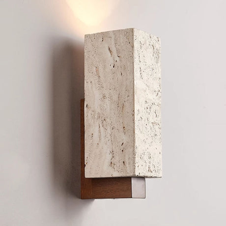 The lit block at an angle, warm light washing the wall above the stone