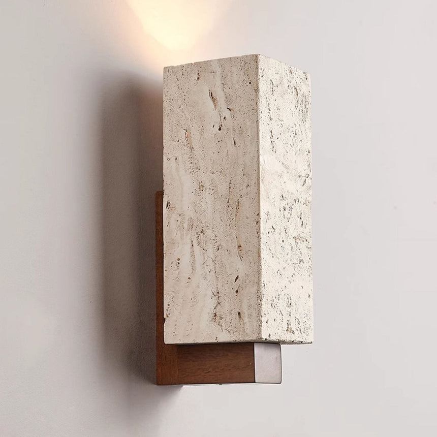 The lit block at an angle, warm light washing the wall above the stone
