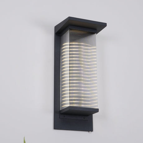 The lantern lit on a gray wall, the light banded by the ribs