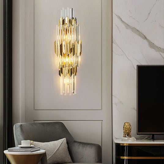 The sconce lit on a paneled wall between a gray armchair and a TV