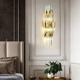 The sconce on a white paneled wall beside a headboard above a plant