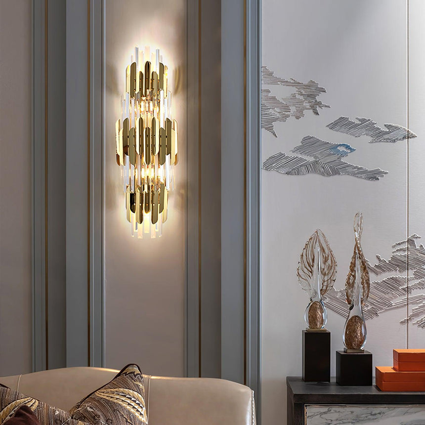 The sconce lit above a sofa with cushions beside a painted mural