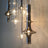 A row of tapered smoke glass spindles lit in front of a dark wall
