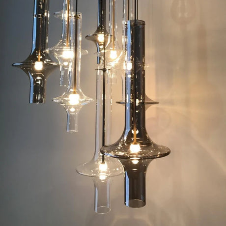 A row of tapered smoke glass spindles lit in front of a dark wall