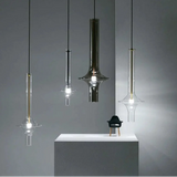 Three spindles hung at staggered heights in a dark lounge beside a low console