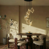 A short cascade lit above a round dining table with chairs and a potted plant