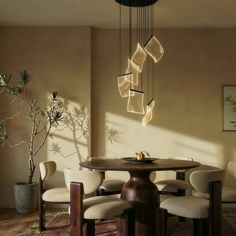 A short cascade lit above a round dining table with chairs and a potted plant
