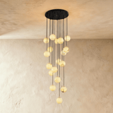 Eighteen lit alabaster spheres in the longest cascade, on a black plate