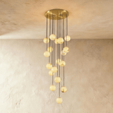 Eighteen lit alabaster spheres, the longest cascade, on a brass plate