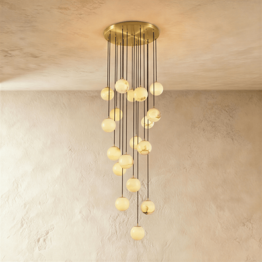 Eighteen lit alabaster spheres, the longest cascade, on a brass plate