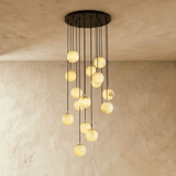 Fifteen lit stone spheres in a long cascade from a wide black ceiling plate