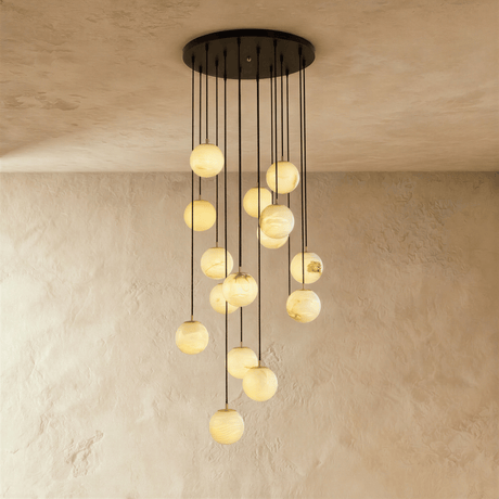 Fifteen lit stone spheres in a long cascade from a wide black ceiling plate