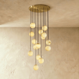 Fifteen lit stone spheres in a long cascade from a brass ceiling plate