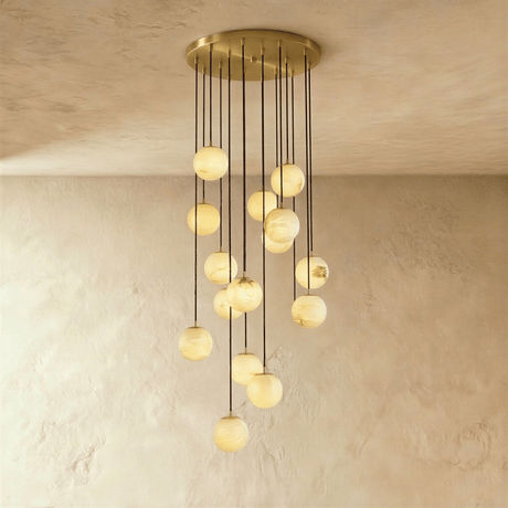 Fifteen lit stone spheres in a long cascade from a brass ceiling plate