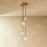 Five lit stone spheres at stepped heights below a brass ceiling plate