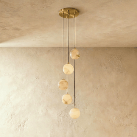 Five lit stone spheres at stepped heights below a brass ceiling plate