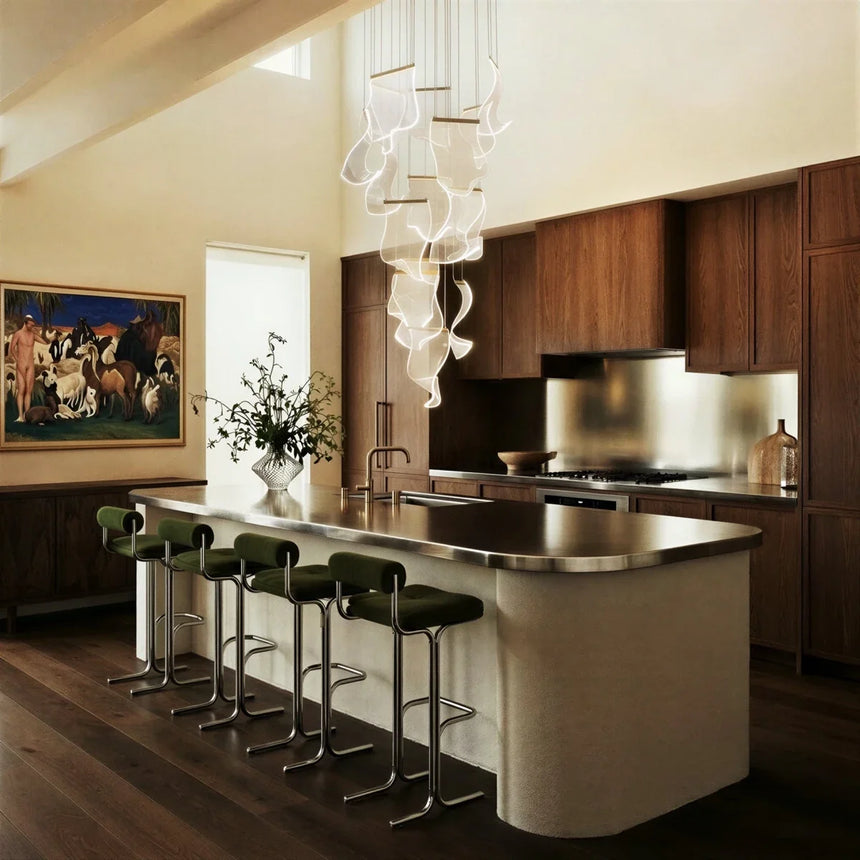 The cascade falling beside a kitchen island with stools under a high sloped ceiling