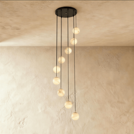 Nine lit alabaster spheres on black cords cut to different lengths
