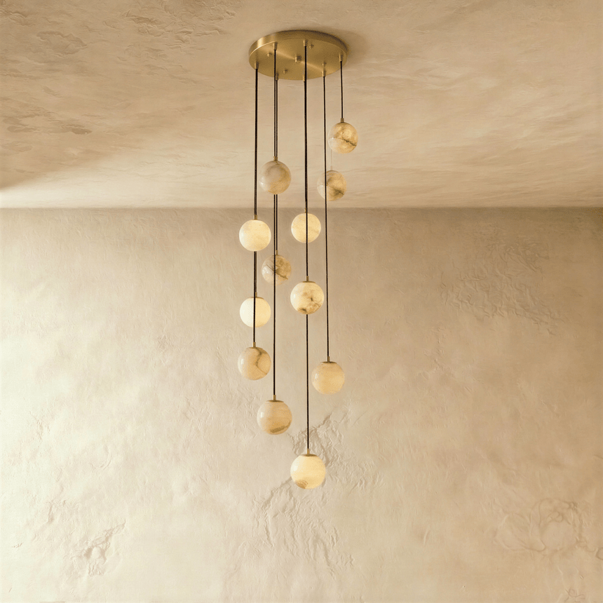 Nine lit stone spheres dropping at different lengths from a brass plate