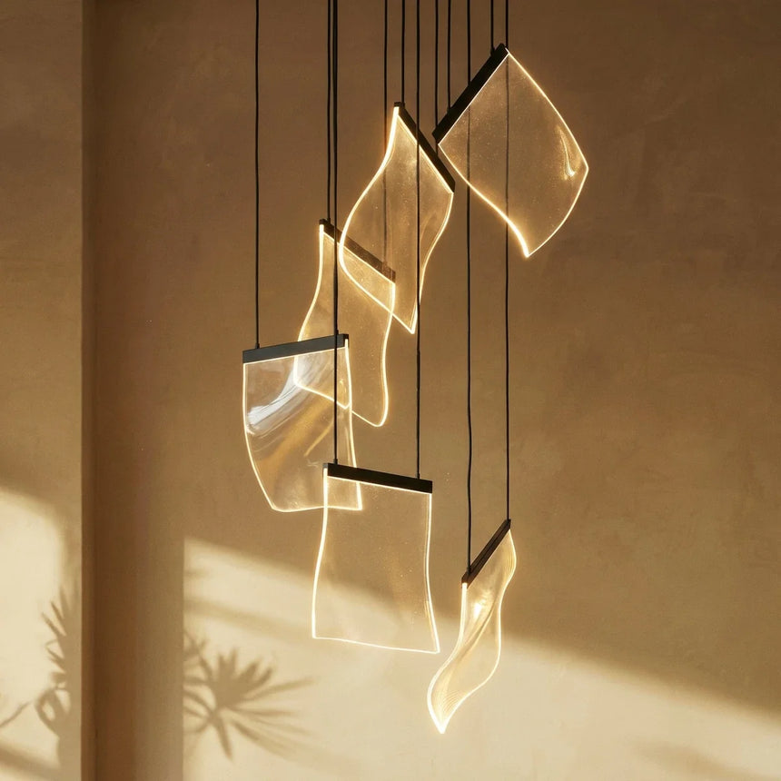 Sunlight crossing a few of the sheets, throwing their curved shadows on a wall