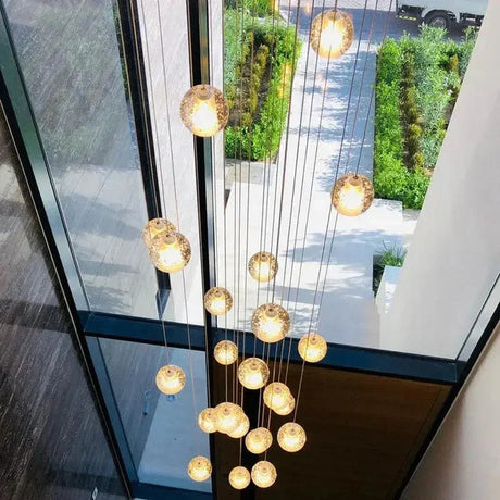 Amber lit spheres seen through a tall window with a garden beyond