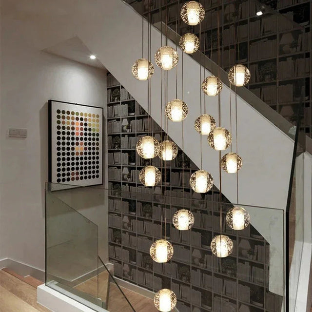 Crystal spheres spiralling beside a glass balustrade in a lit stairwell