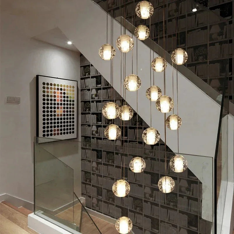Crystal spheres spiralling beside a glass balustrade in a lit stairwell