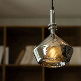 The faceted amber shade lit above a shelf with the facets catching light