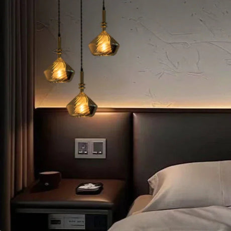 Two faceted shades lit beside a bed with a wooden headboard and shelf